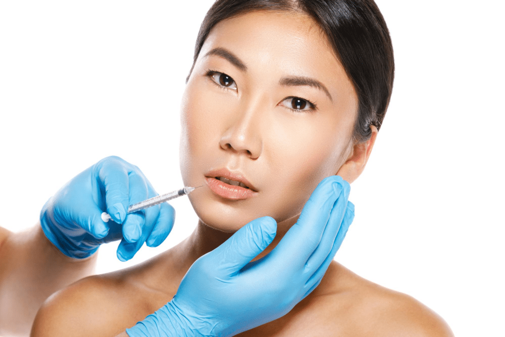 Aesthetic practitioner administering Aquashine dermal filler treatment for facial rejuvenation on an Asian woman, highlighting the precision and care in the procedure.