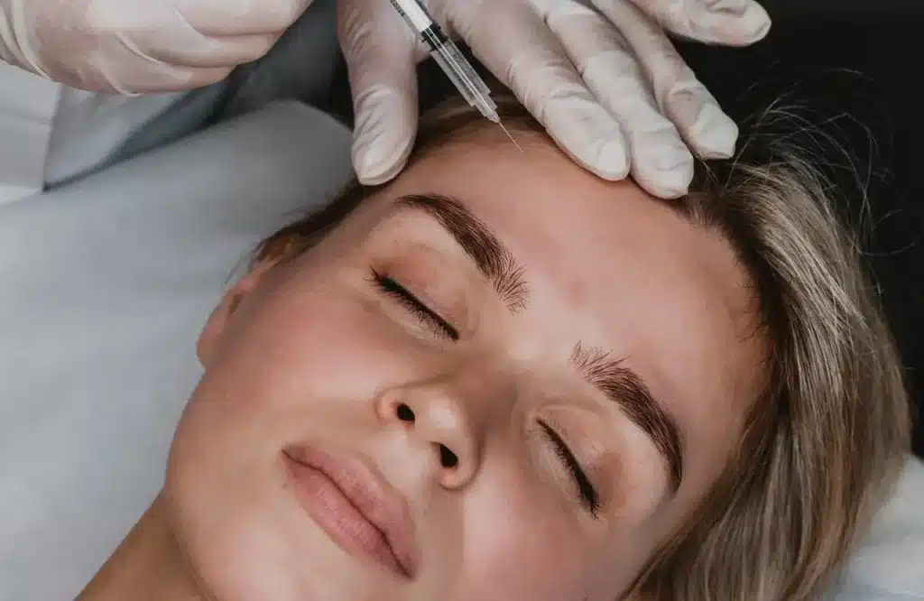 Young female patient getting forehead Botox injections