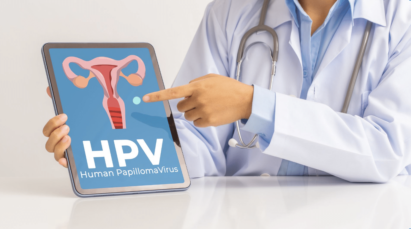 A healthcare professional wearing a white coat and stethoscope points to a tablet displaying an illustration of the female reproductive system and the words "HPV Human PapillomaVirus.