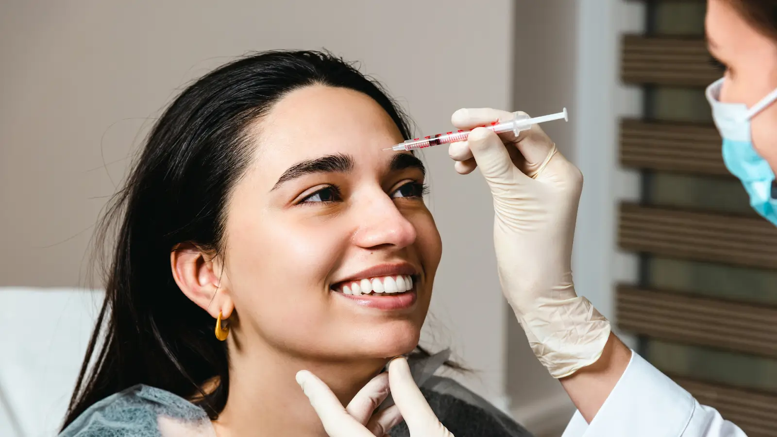 A female patient eagerly receives skin booster injection treatment.