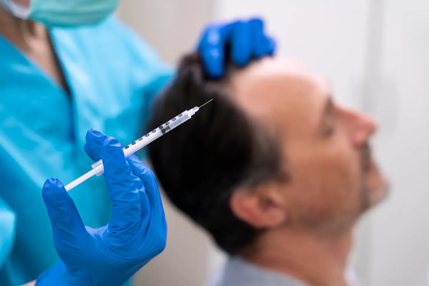 a healthcare provider holds up an injection that will target the scalp