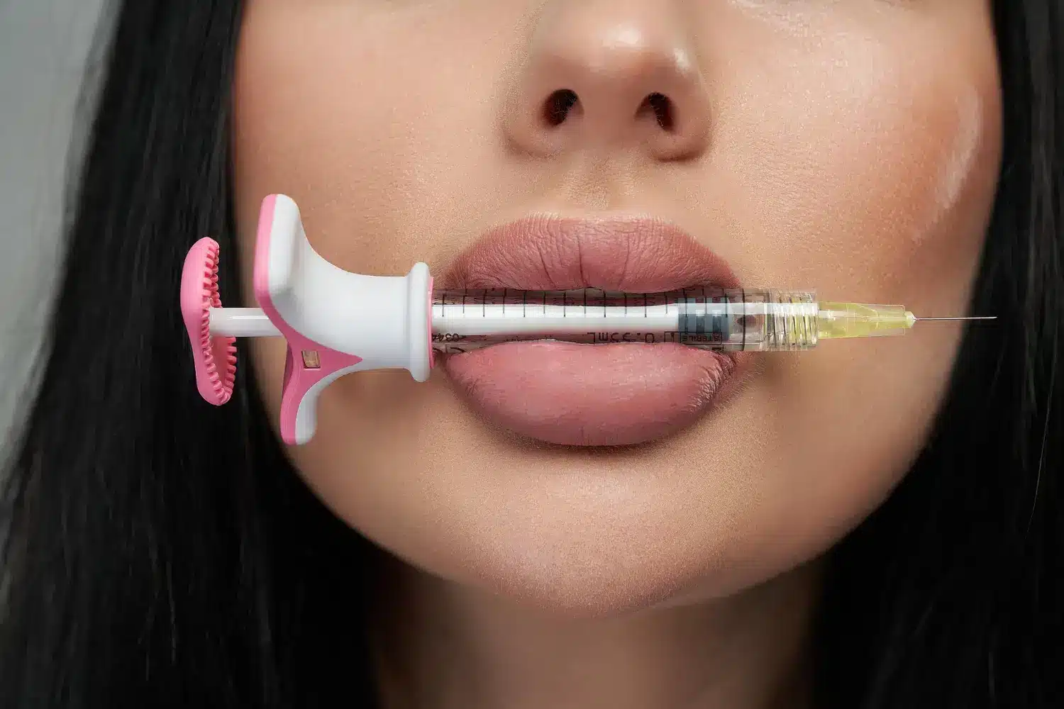 syringe in the mouth of a woman