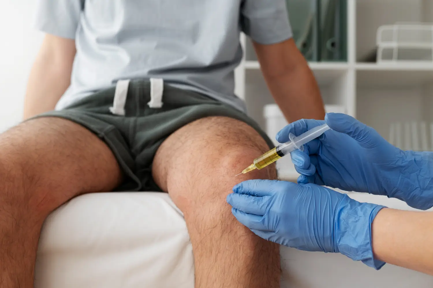 A healthcare professional injects the knee joint.