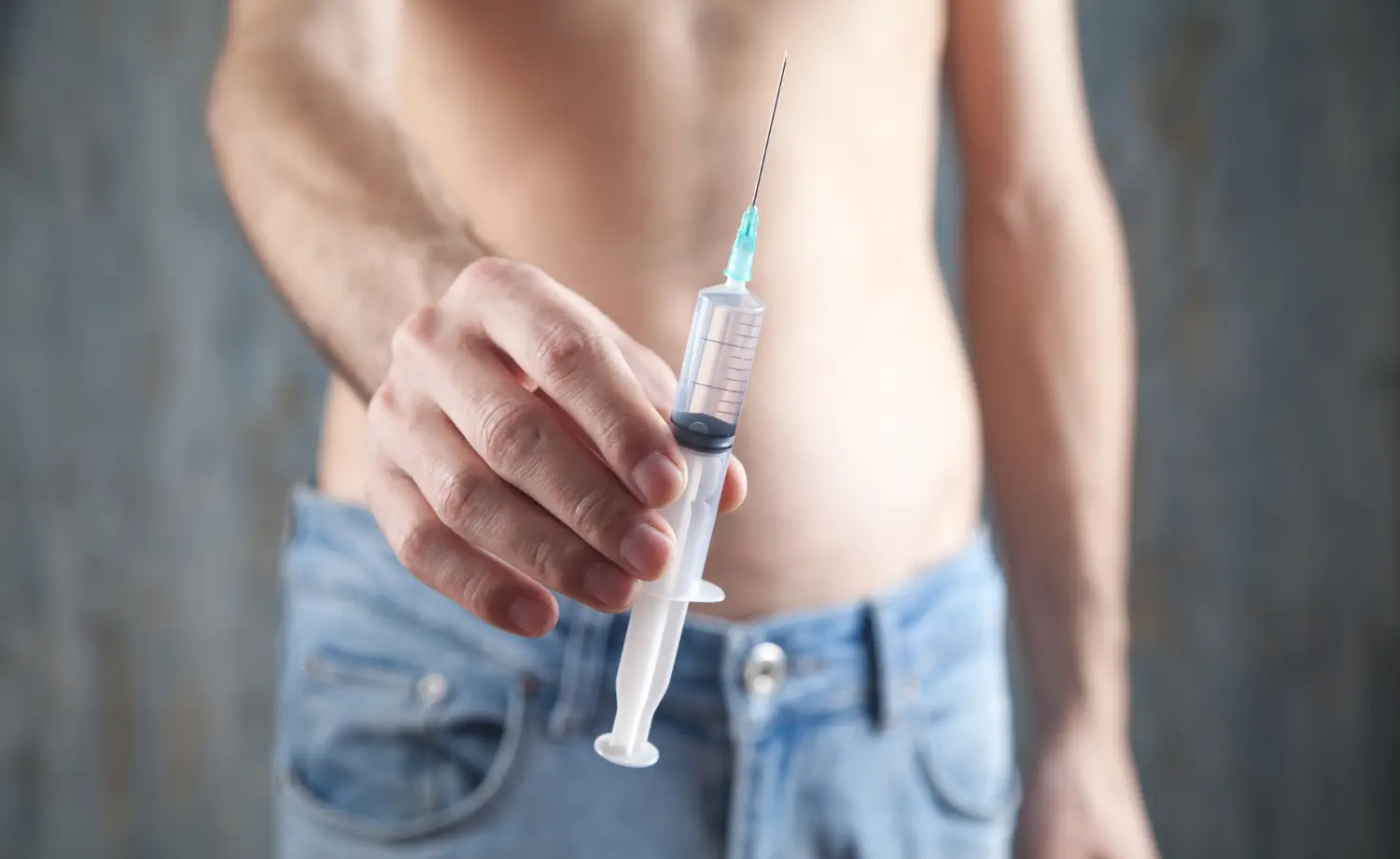 man holds syringe