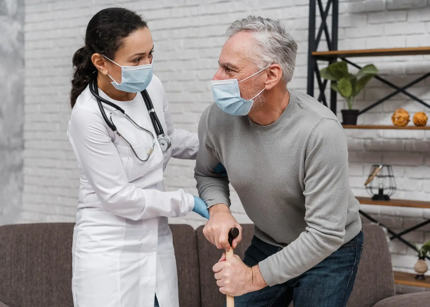 doctor helping patient get up and walk