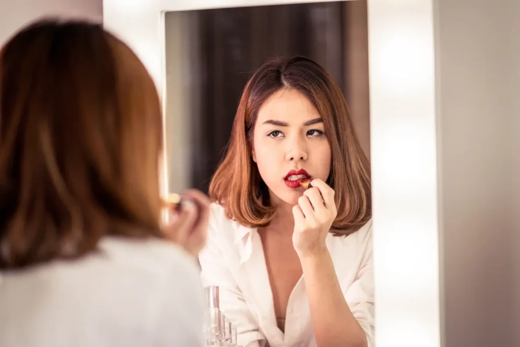 putting lipstick to her lips that made it red